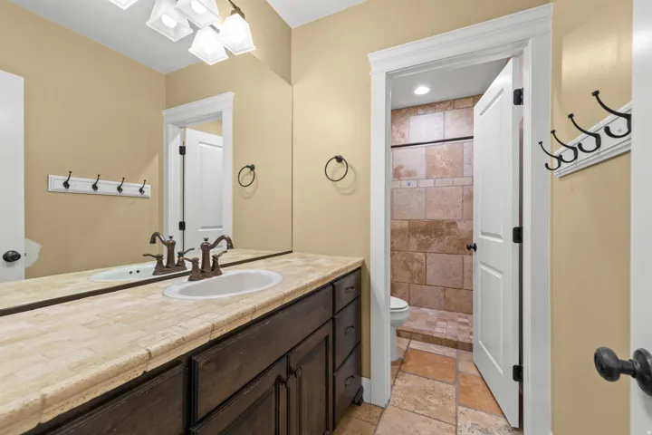Bathroom vanity with a rectangular undermount sink and oil-rubbed bronze faucet, set into a tiled countertop