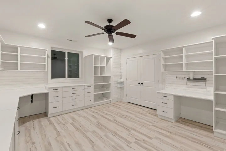 Dedicated room featuring extensive built-in cabinetry, shelving, and desk space