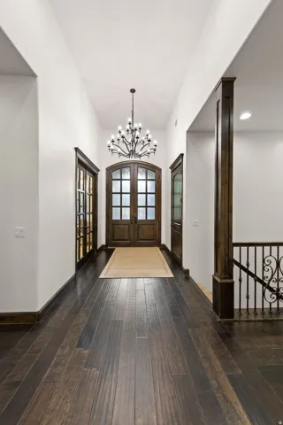 Entryway featuring dark wood-finish flooring and a wrought iron chandelier