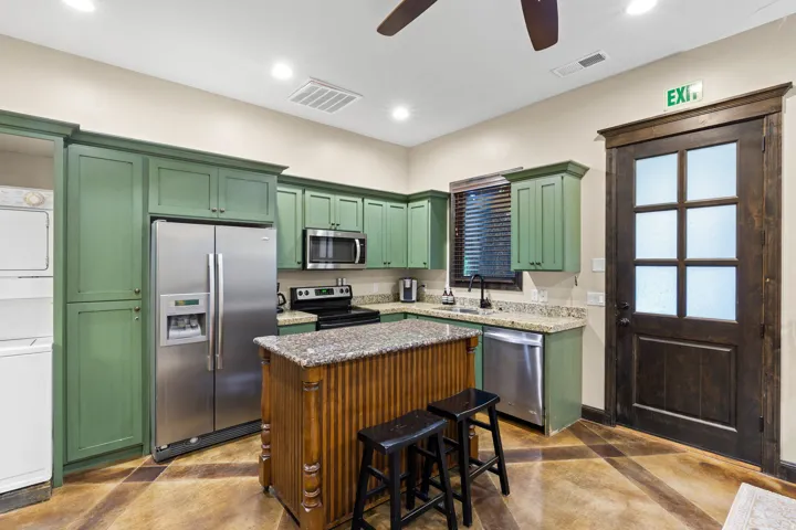 Kitchen featuring green cabinetry, granite countertops, and stainless steel appliances