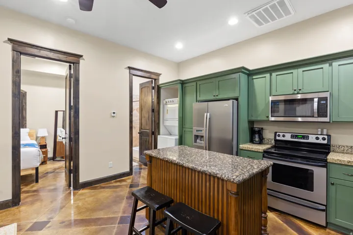 Kitchen featuring green shaker-style cabinetry and granite countertops