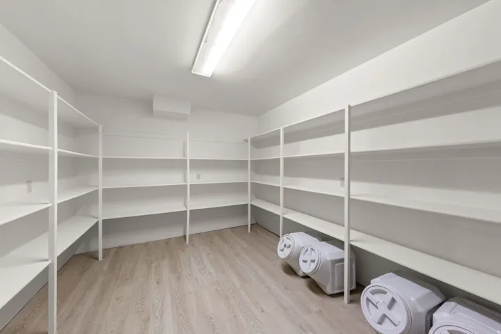 Spacious storage room featuring extensive white shelving
