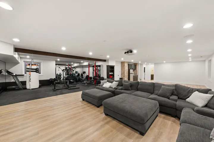 Spacious lower level featuring light wood-finish flooring, recessed lighting, and a built-in projector