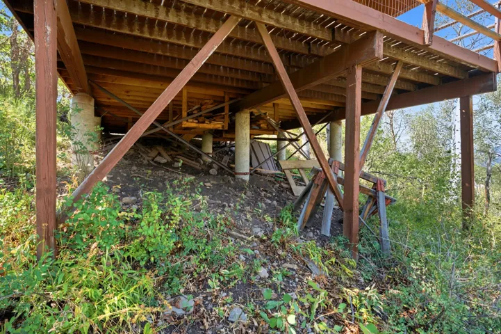 Elevated wood deck with exposed support beams and concrete pier foundations