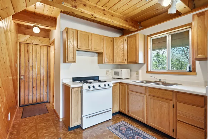 Kitchen featuring wood-finish ceiling, exposed wood beams, and natural wood cabinetry