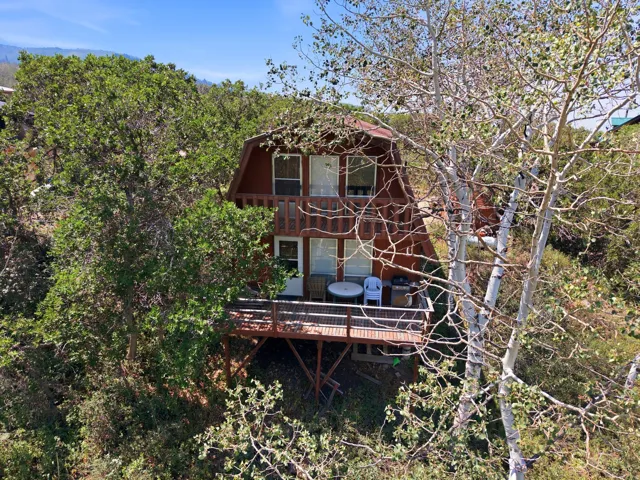 A-frame property featuring a natural wood exterior and an elevated deck