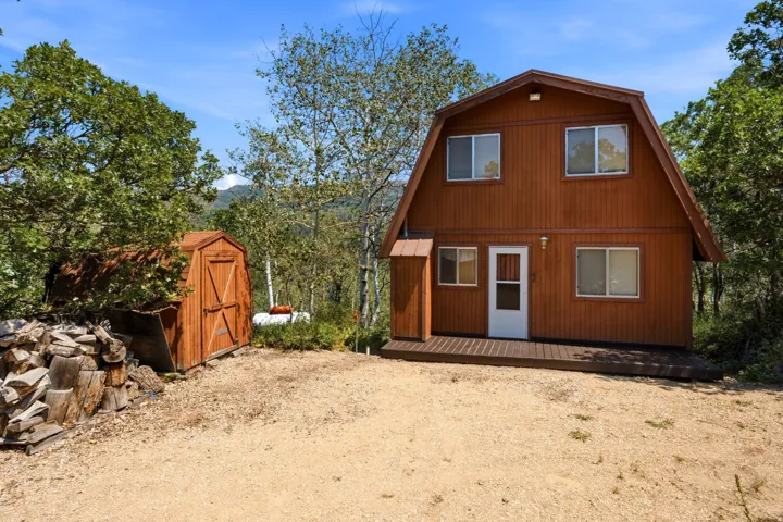 Barn-style residence featuring natural wood siding and a ground-level deck