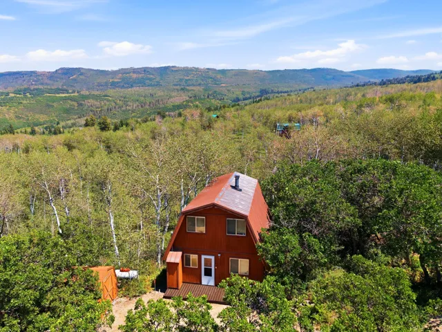A-frame residence featuring a distinctive gambrel roofline and a rich wood-tone exterior