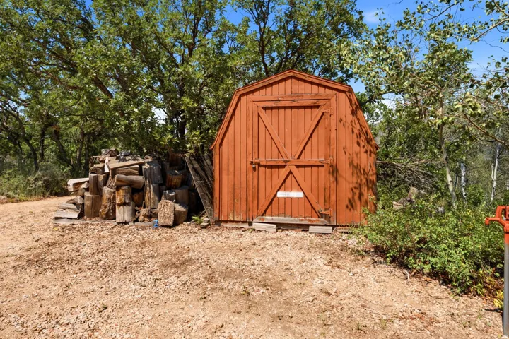 Freestanding wood shed with a gabled roof and barn-style doors