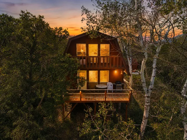 A-frame style residence featuring a wood-paneled exterior and multiple large windows