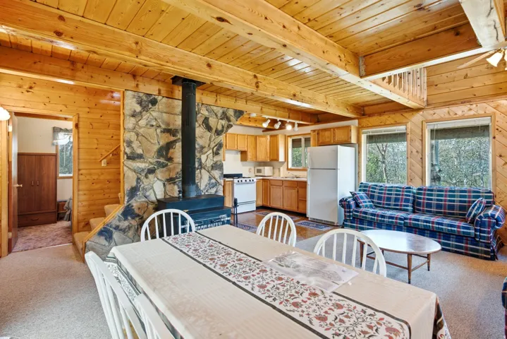 Open-concept room featuring wood-finish walls and exposed beam ceilings