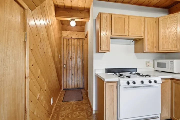 Kitchen area featuring light wood-finish cabinetry and white countertops