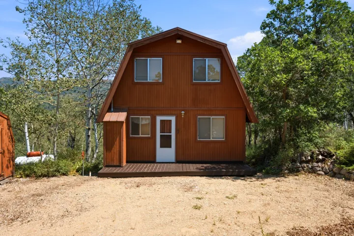 A-frame style exterior with vertical wood siding and a wooden deck