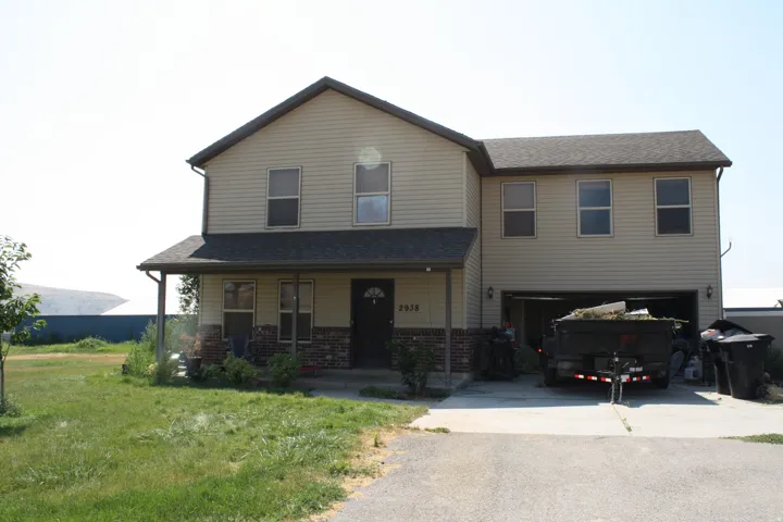 Two-story residence featuring light-colored siding and a covered front porch