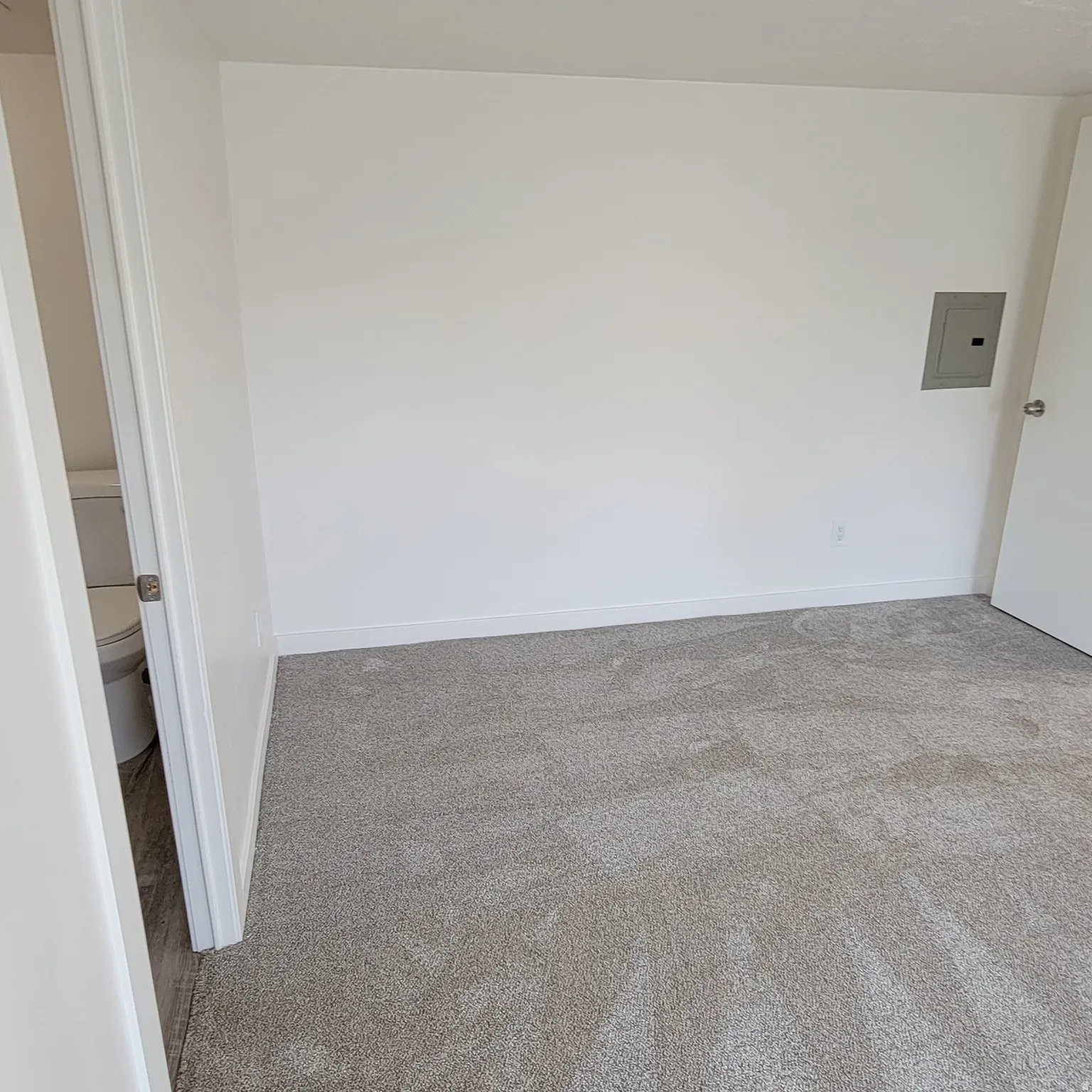 Wall-to-wall carpeting with light-colored walls and baseboards