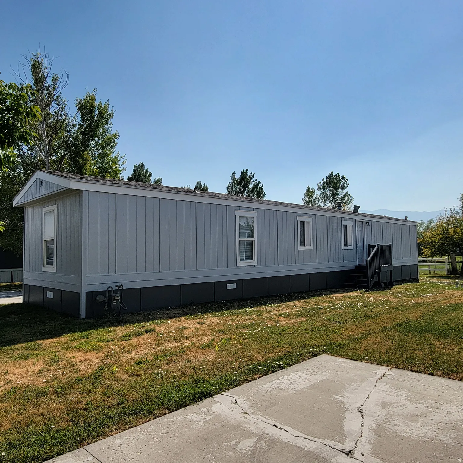 Light blue siding exterior with white trim and dark foundation