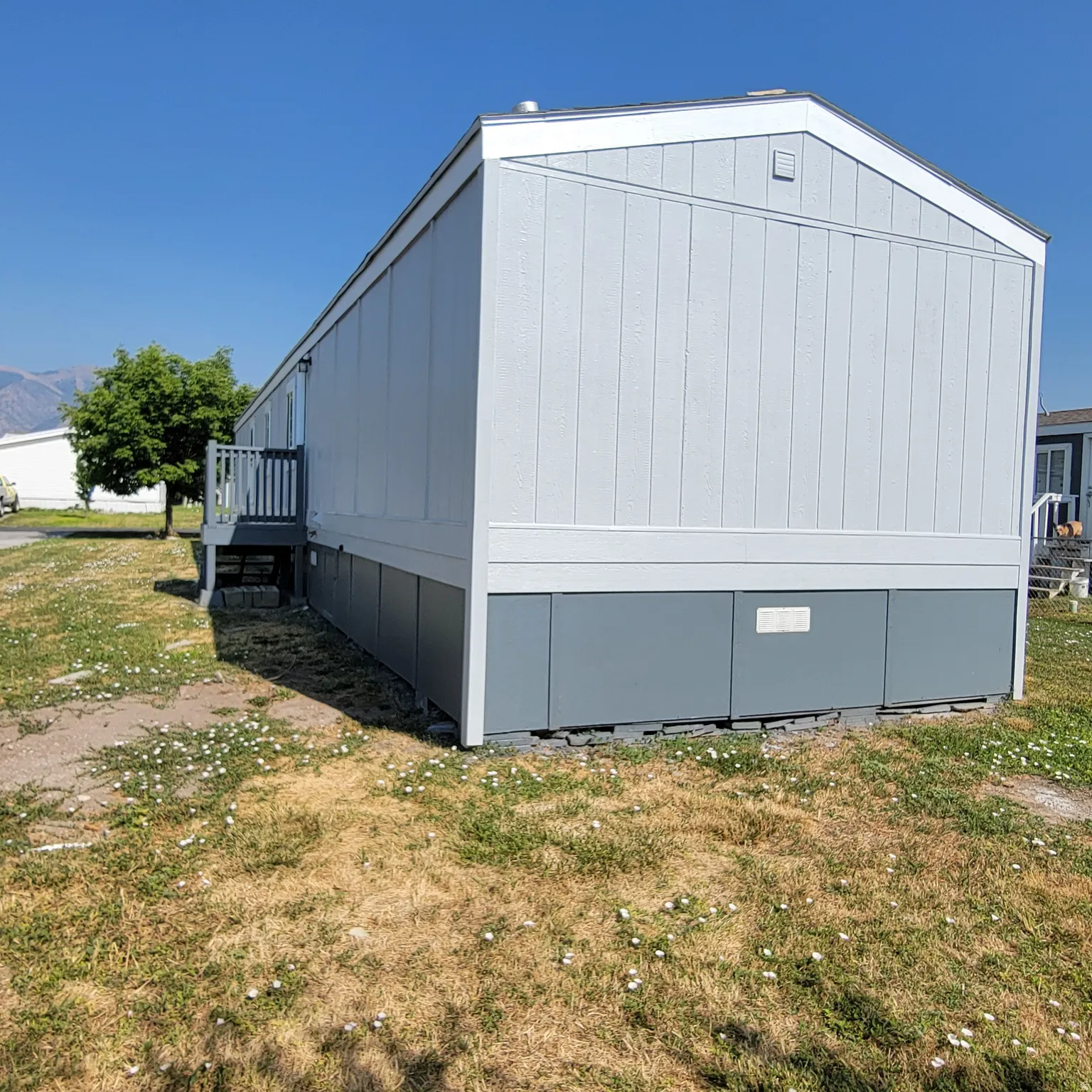 Light-colored exterior siding with contrasting darker skirting