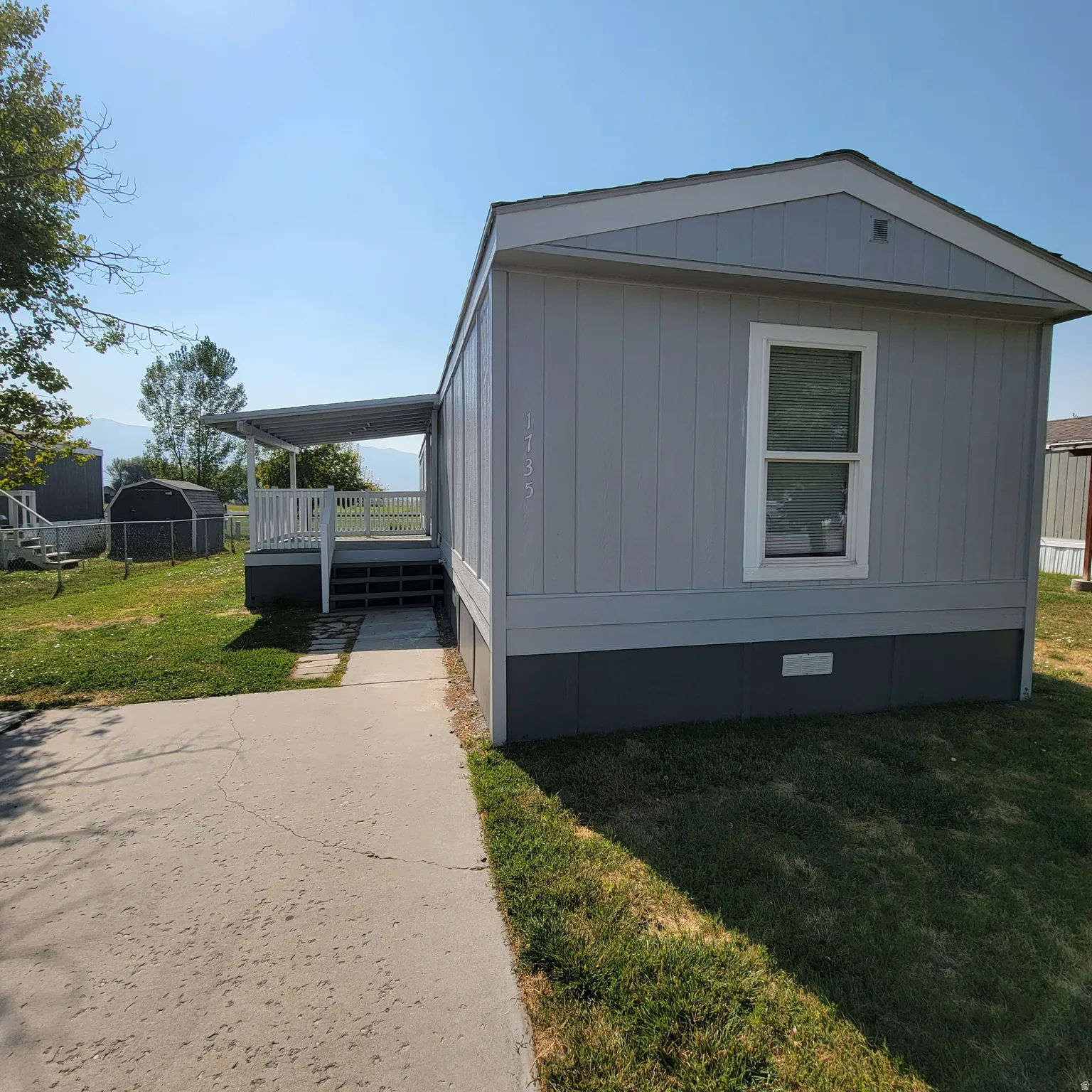 Light gray siding exterior with white trim and a covered porch