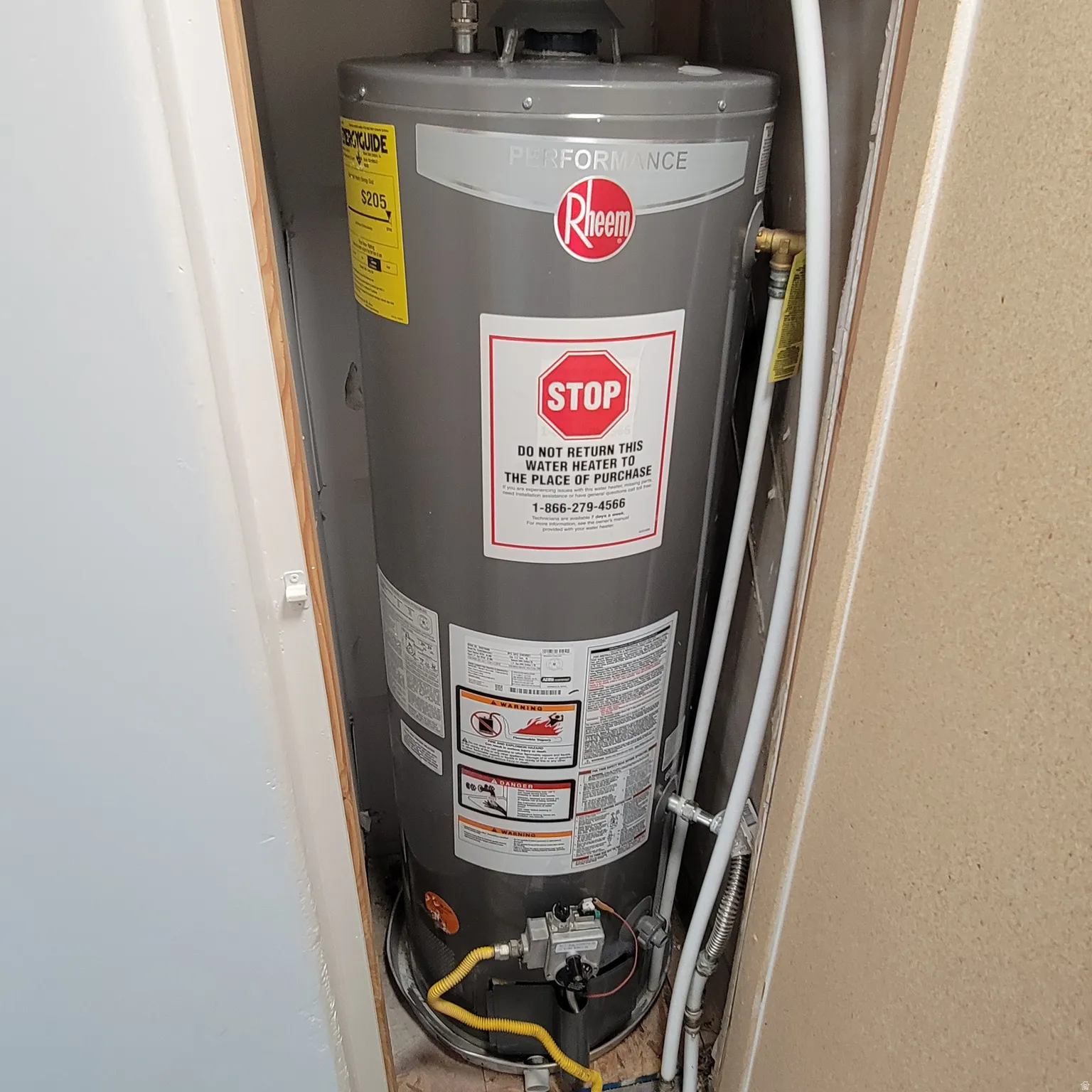 Modern Rheem Performance water heater installed within a utility closet
