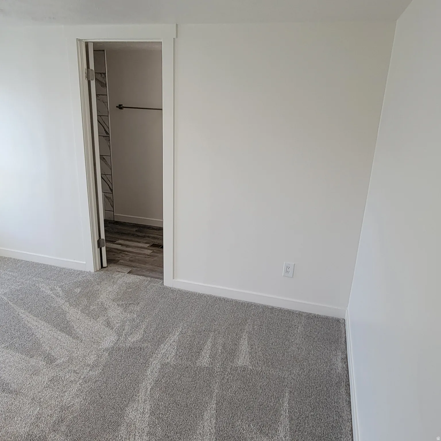 Plush gray carpeting contrasts with bright white walls and trim