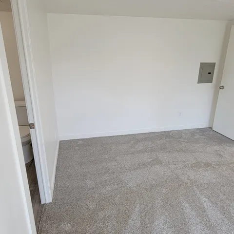 Wall-to-wall carpeting with light-colored walls and baseboards