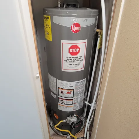 Modern Rheem Performance water heater installed within a utility closet