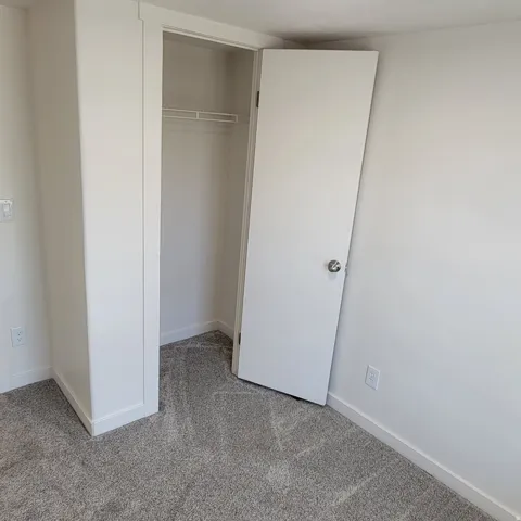 Neutral-toned carpet flooring with white baseboards and trim