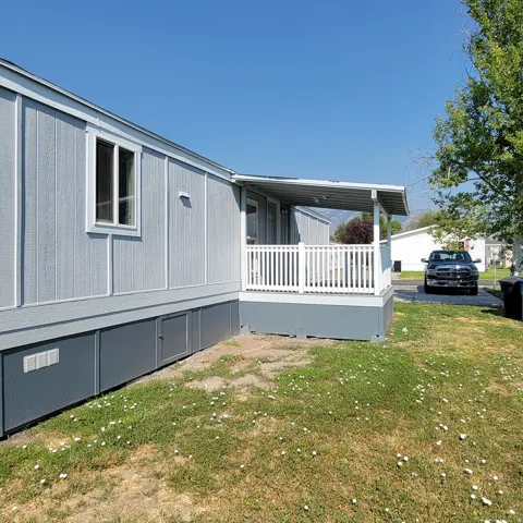 Exterior featuring light blue siding, white trim, and a covered porch with white railings