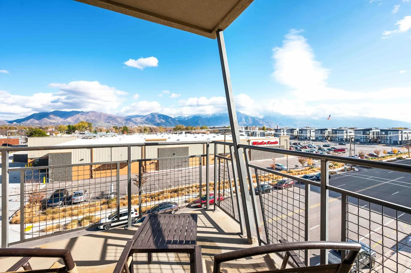 Private balcony with metal grid railings and mountain backdrop