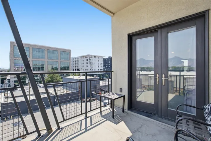 Private balcony featuring a concrete floor, dark metal railing, and double glass-paneled doors