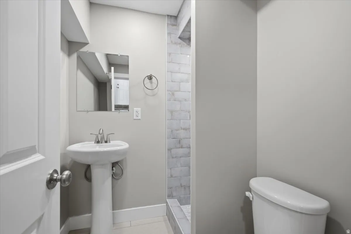 Pedestal sink with polished chrome faucet and square wall mirror