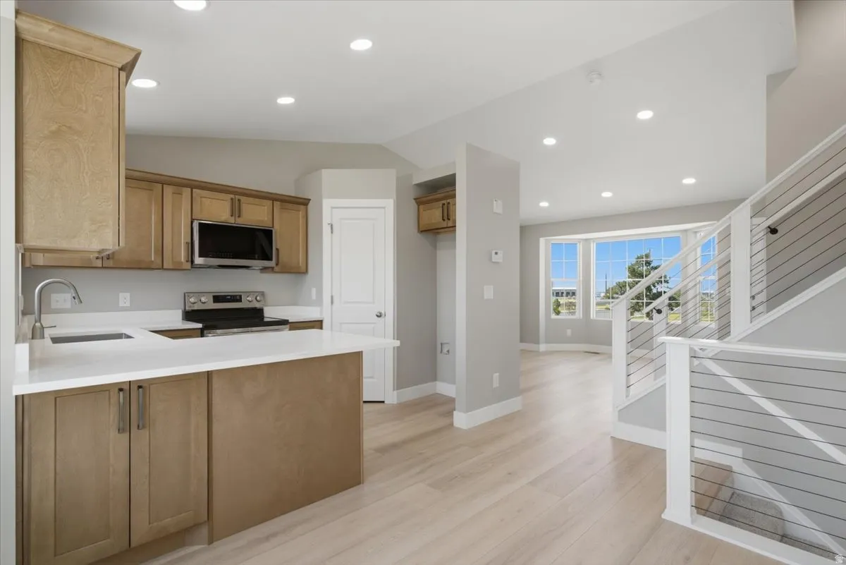 Kitchen featuring wood-finish cabinetry, white countertops, and stainless steel appliances