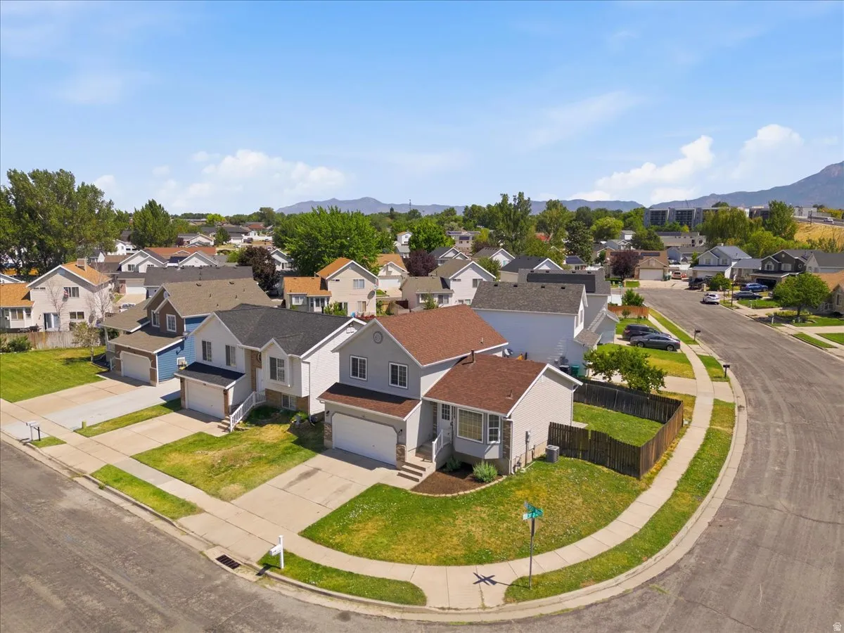 Residential neighborhood featuring single-family homes with attached garages, paved driveways, and manicured lawns