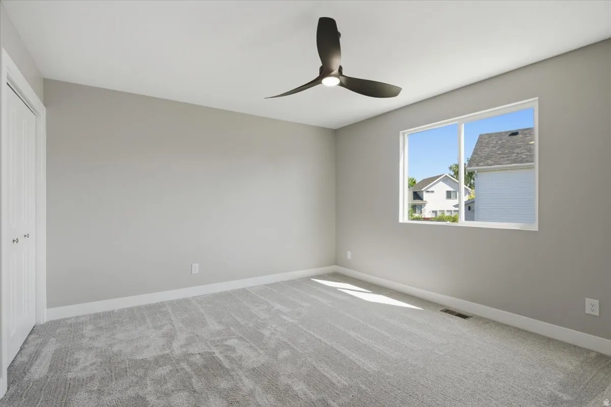 Room featuring broadloom carpeting, a contemporary ceiling fan with integrated lighting, and a single window