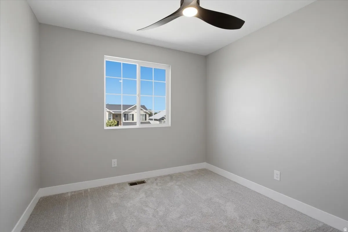 Room featuring light gray walls, gray carpeting, and white baseboards
