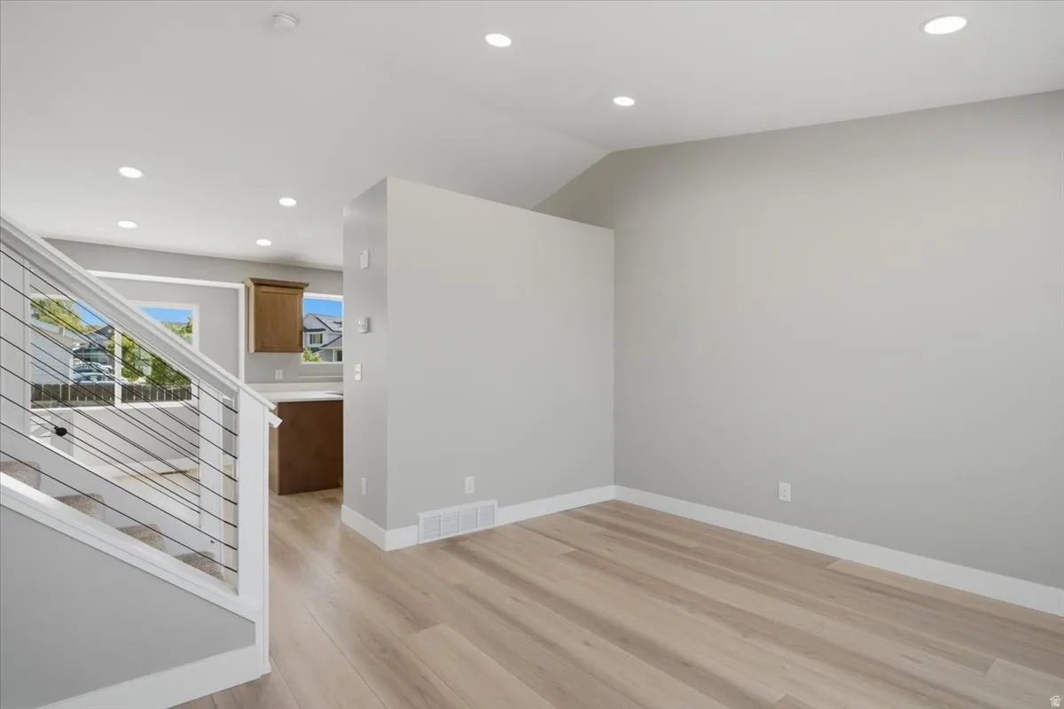 Spacious interior with light wood-finish flooring and recessed lighting