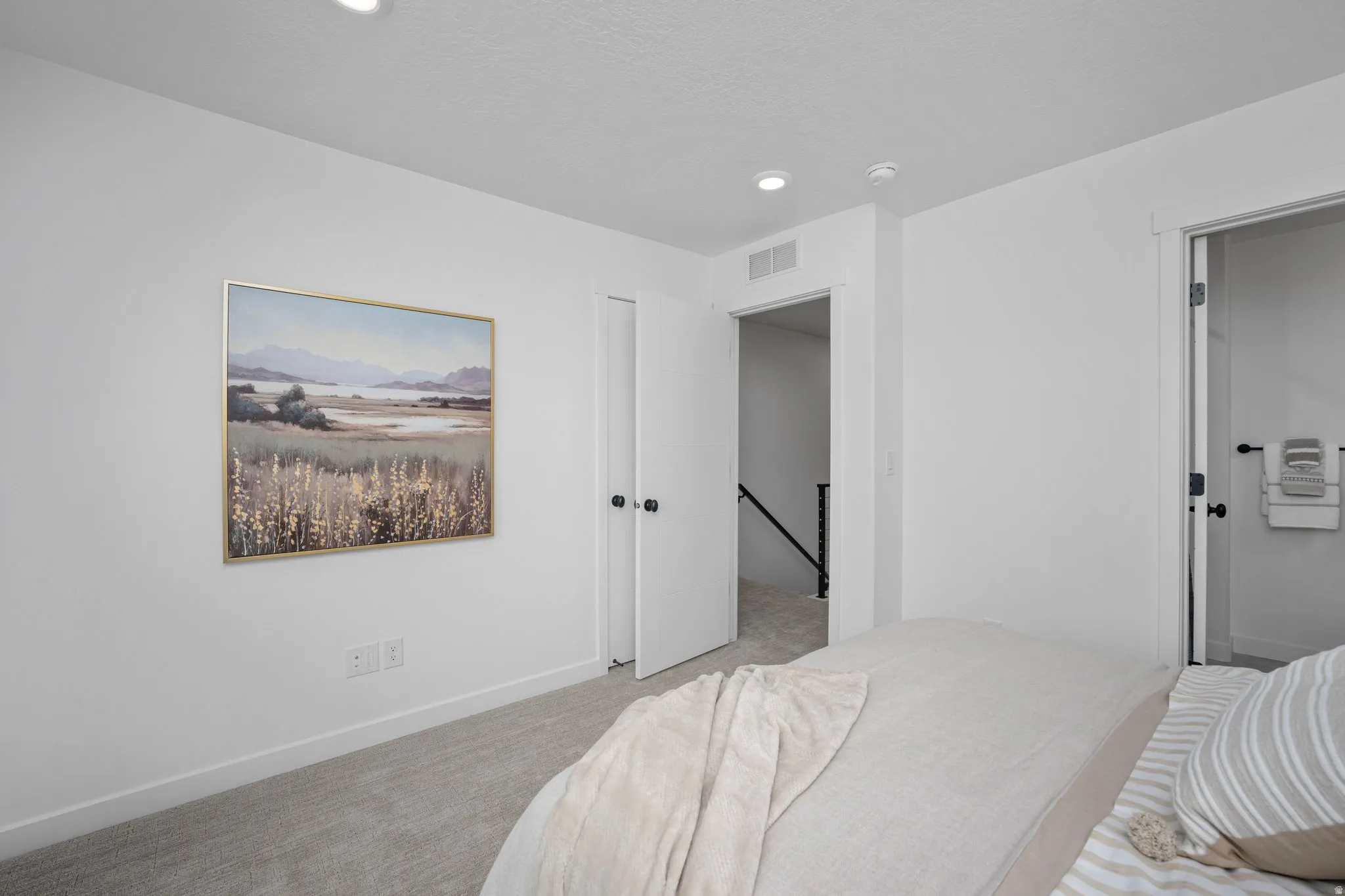 Bright interior room featuring light gray carpet, white painted walls, and recessed lighting