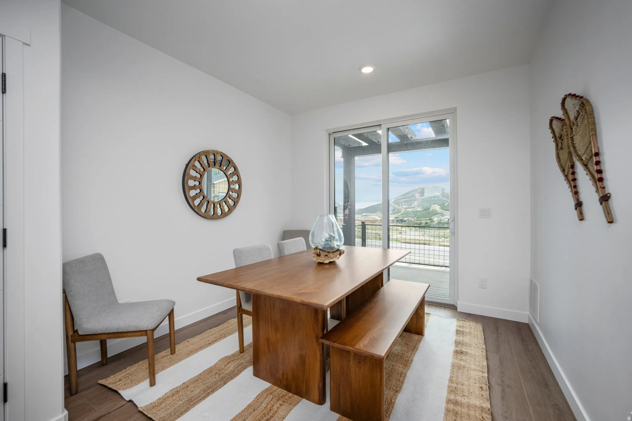 Dining area featuring wood-finish flooring, recessed lighting, and a sliding glass door leading to an outdoor balcony