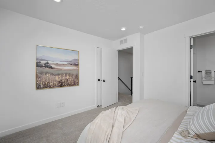 Bright interior room featuring light gray carpet, white painted walls, and recessed lighting