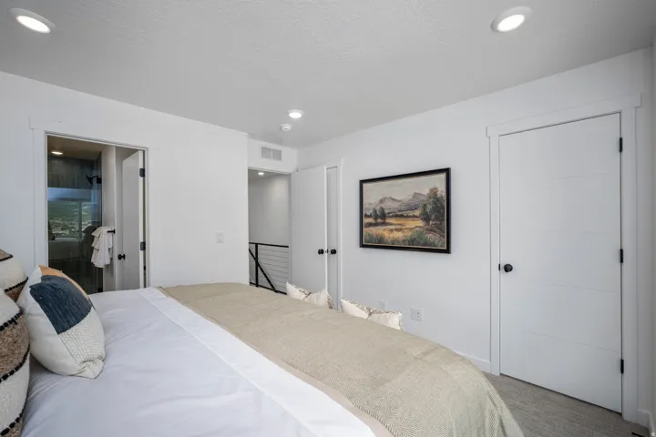 White interior with recessed lighting, a modern horizontal paneled door, and durable wood-finish flooring