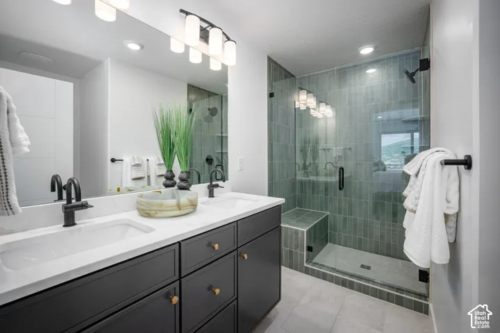Modern bathroom featuring a dual vanity with dark cabinetry, white countertops, and matte black fixtures