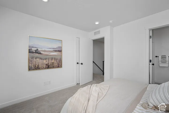 Bright interior room featuring light gray carpet, white painted walls, and recessed lighting