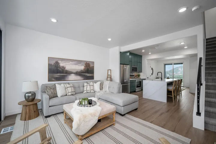 Open-concept living space featuring wood-finish flooring, recessed lighting, and a neutral color palette
