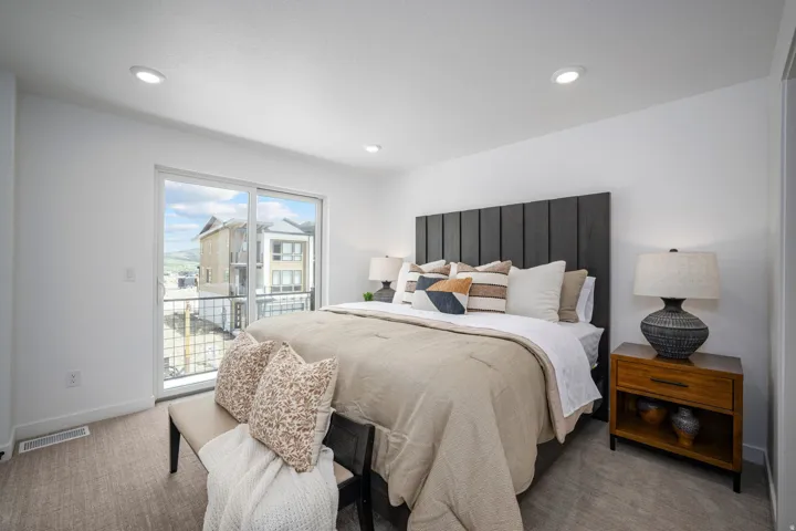 Bedroom featuring a sliding glass door to a balcony, recessed lighting, and light-toned carpeting