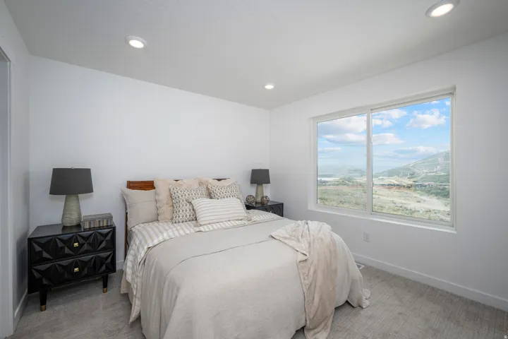 Bedroom featuring a large picture window, recessed lighting, and light-toned carpeting