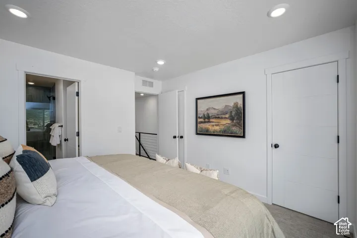 White interior with recessed lighting, a modern horizontal paneled door, and durable wood-finish flooring