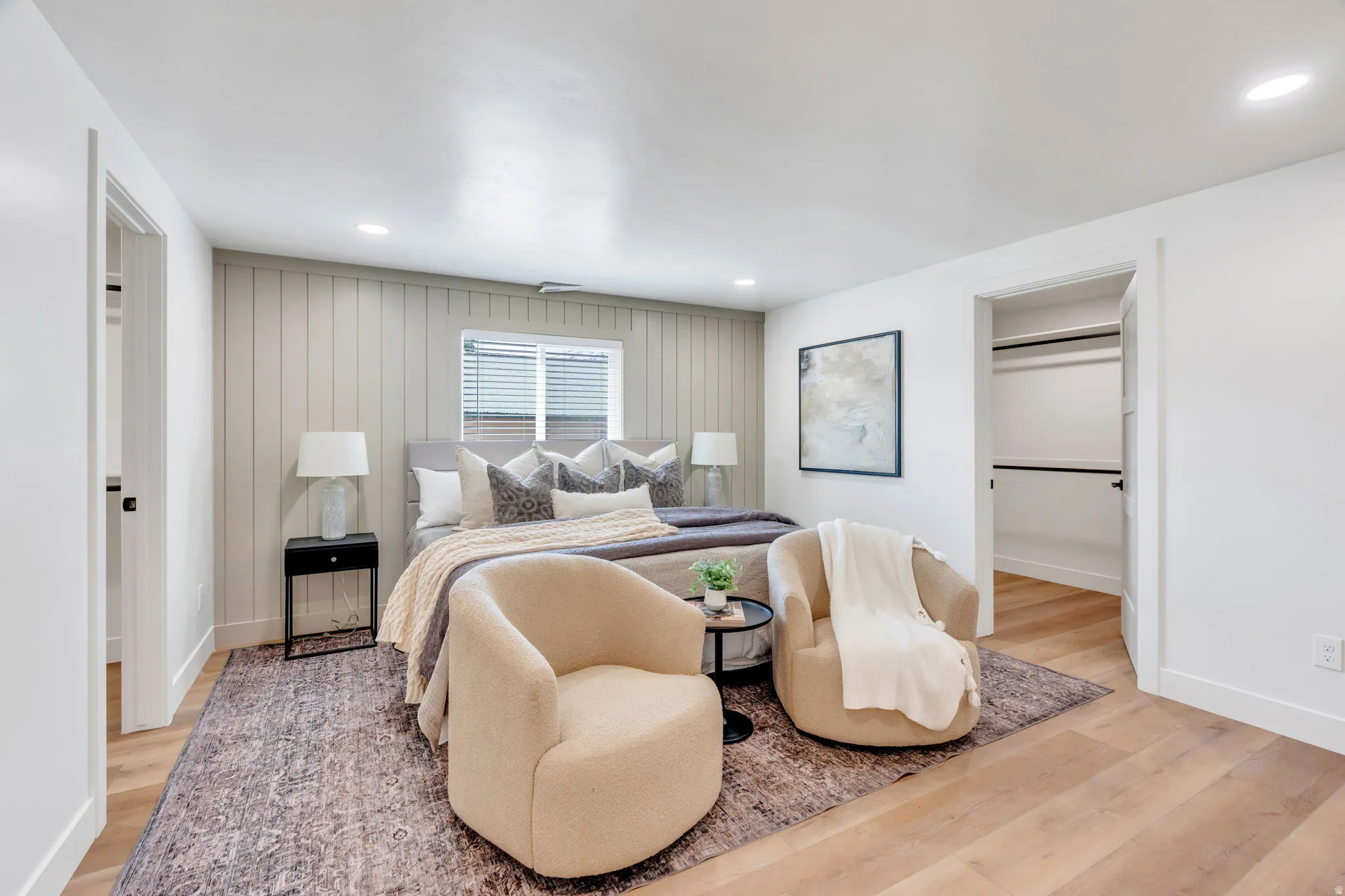 Bedroom featuring a textured accent wall, recessed lighting, and wood-finish flooring