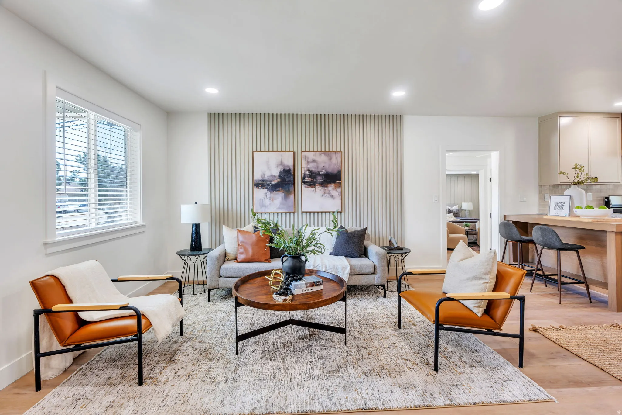 Living area featuring recessed lighting, a modern accent wall, wood-finish flooring, and a window with blinds