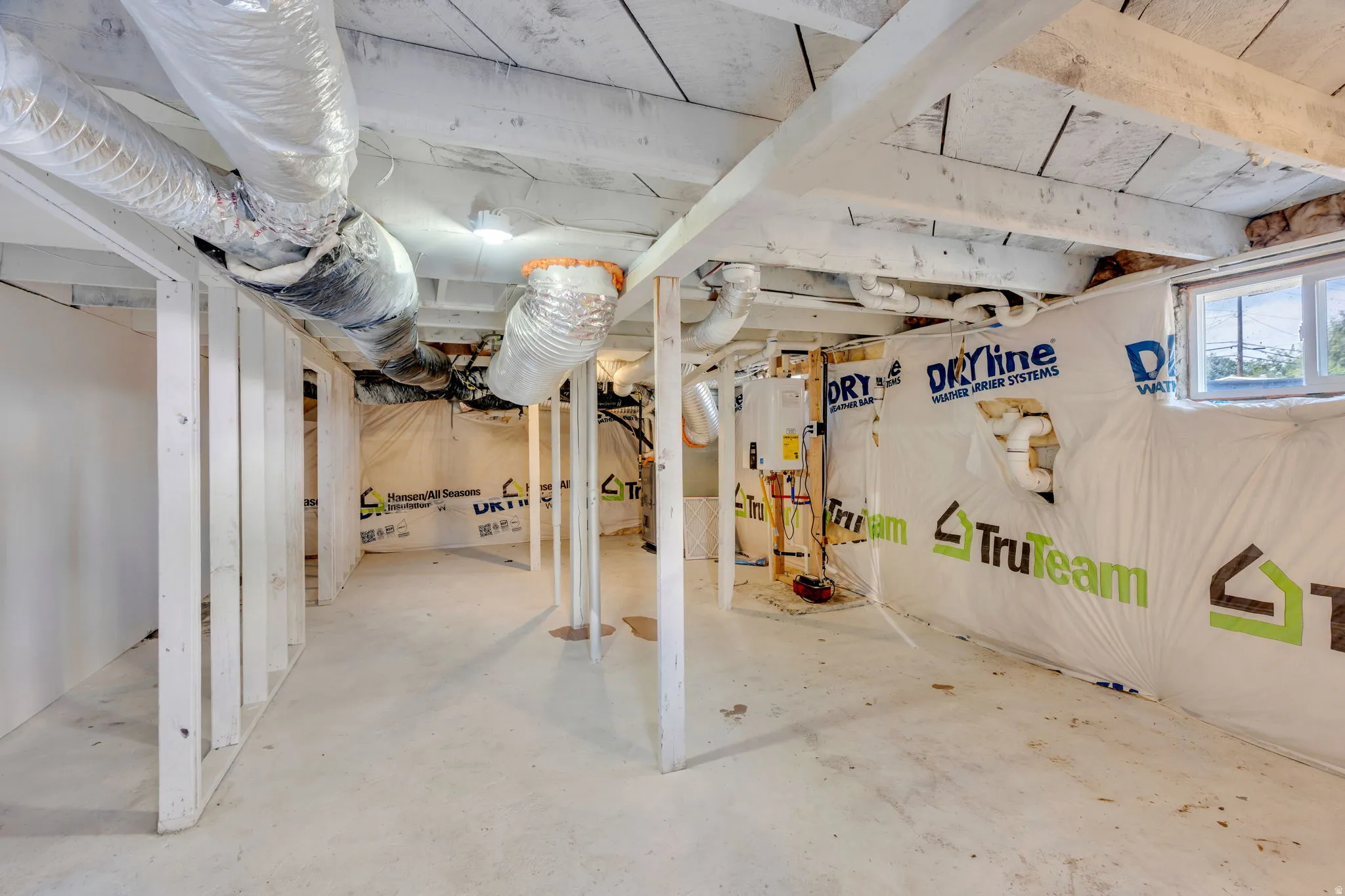 Unfinished basement featuring exposed joists, concrete flooring, and perimeter insulation