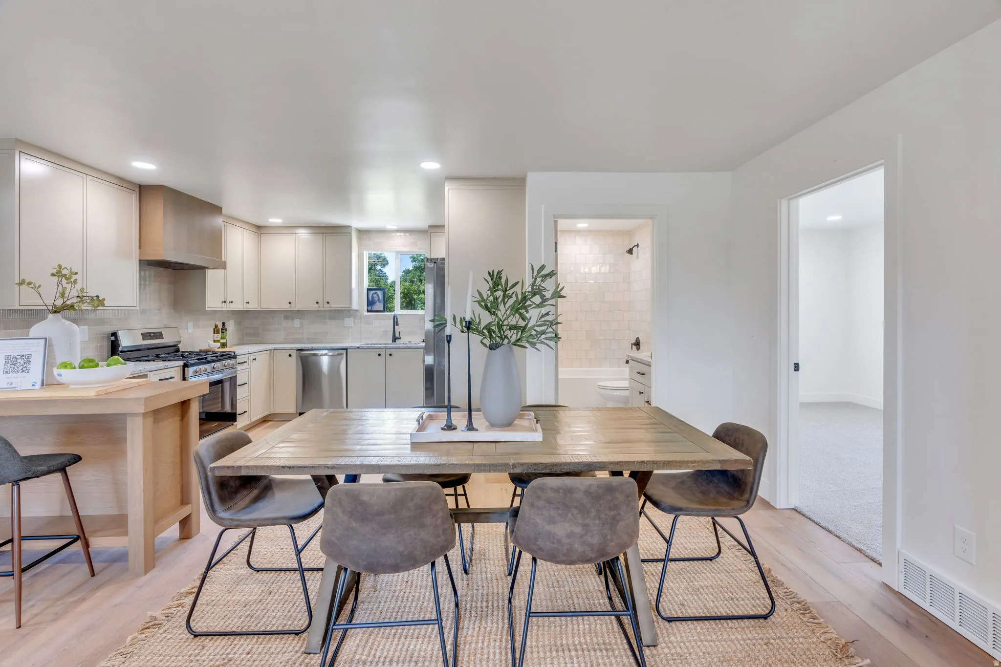 Open-concept living area with wood-finish flooring extending into the kitchen
